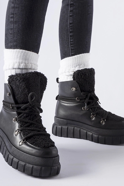 Botas pretas de cano curto sobre uma...