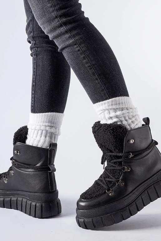 Botas pretas de cano curto sobre uma...