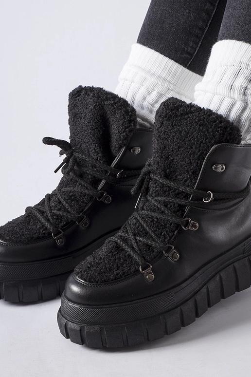 Botas pretas de cano curto sobre uma...