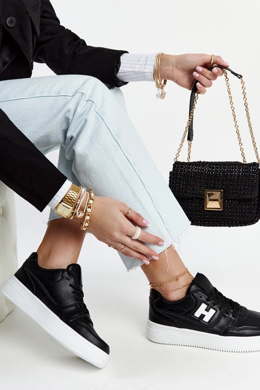 Tênis preto sobre plataforma branca...