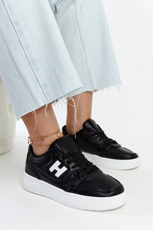 Tênis preto sobre plataforma branca...