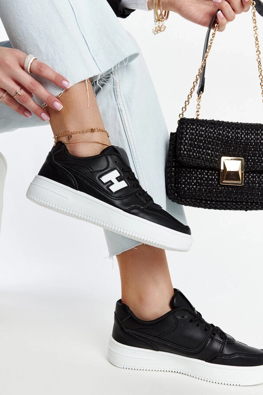 Tênis preto sobre plataforma branca...