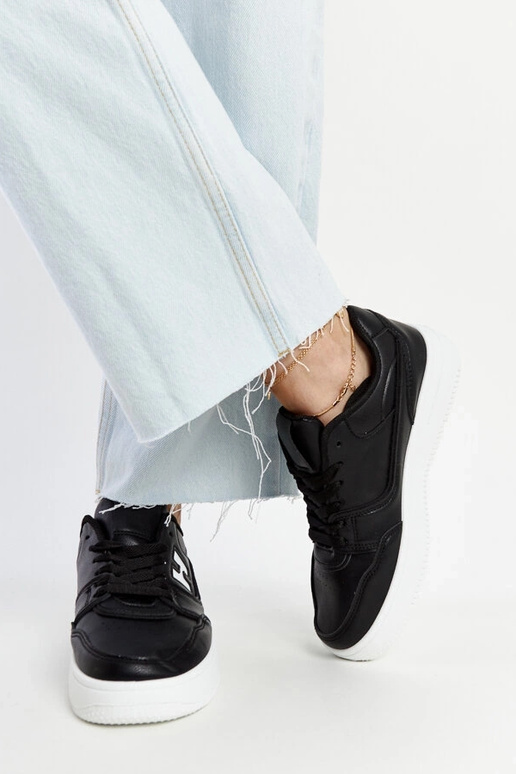 Tênis preto sobre plataforma branca...