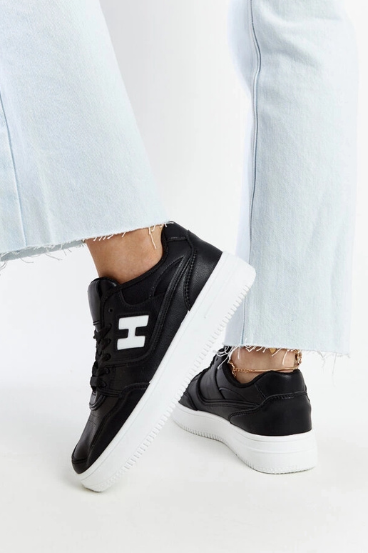 Tênis preto sobre plataforma branca...