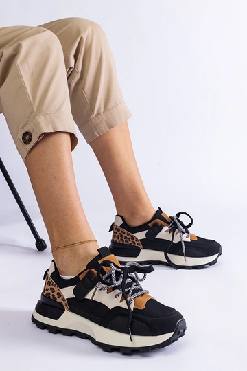 Tênis pretos decorados com...