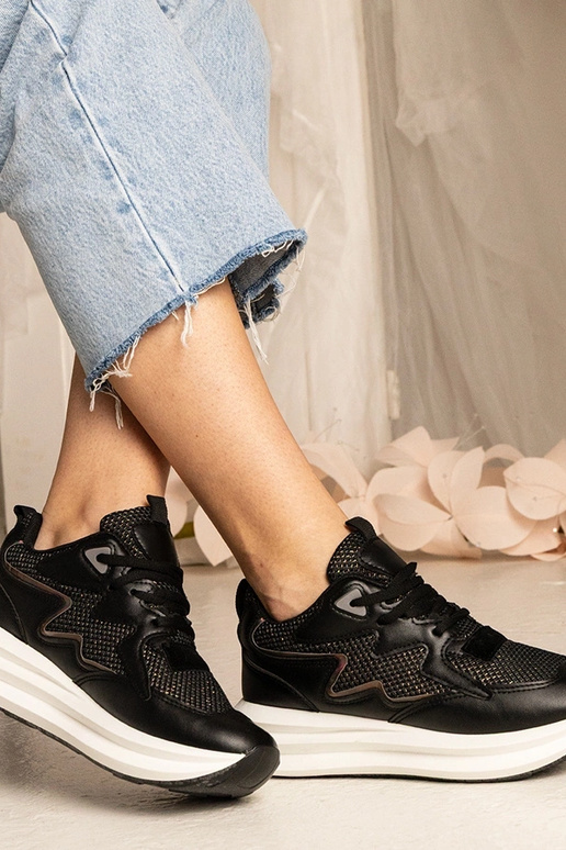 Tênis pretos com elemento holográfico...