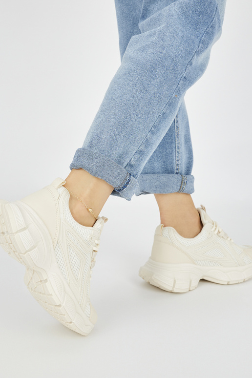 Modelo de tênis na cor bege com sola... Modelo de tênis na cor bege com sola...