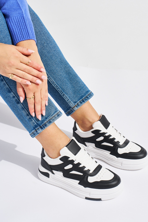 Modelo de tênis branco e preto com... Modelo de tênis branco e preto com...