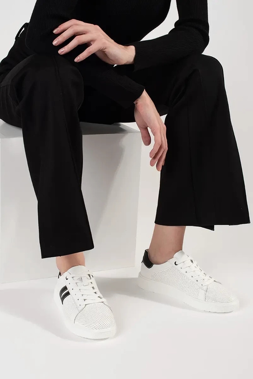 Tênis esportivos na cor branca, em... Tênis esportivos na cor branca, em...