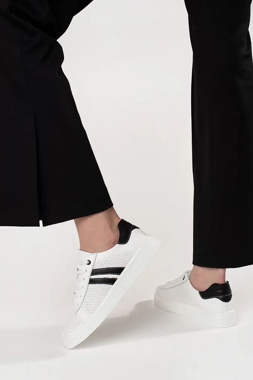 Tênis esportivos na cor branca, em... Tênis esportivos na cor branca, em...