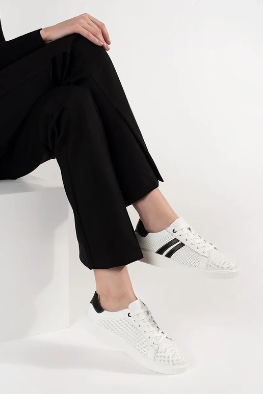 Tênis esportivos na cor branca, em... Tênis esportivos na cor branca, em...