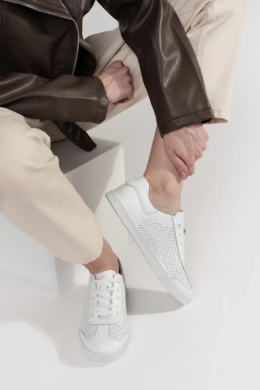 Tênis esportivos brancos perfurados... Tênis esportivos brancos perfurados...