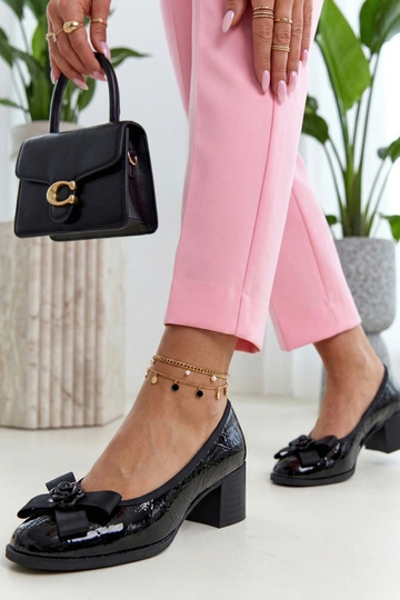 Sapatos de couro envernizados pretos em uma coluna Cambell